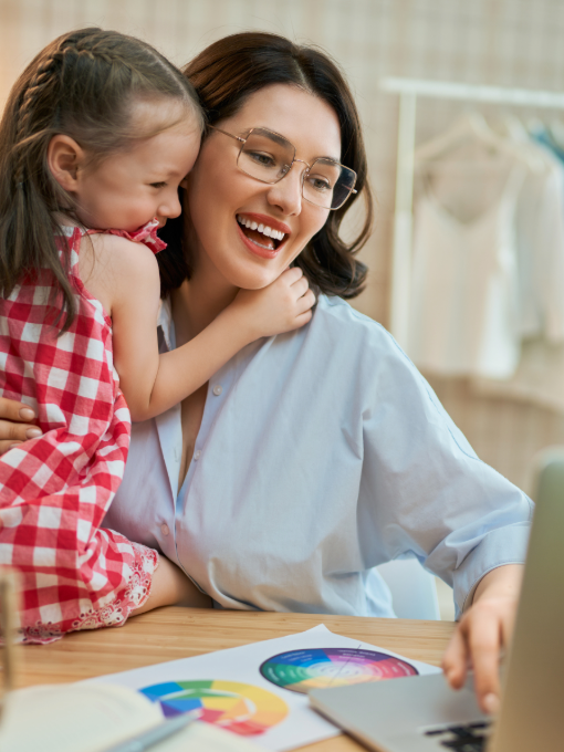 Mão trabalhando com sua filha no colo - MaternAção